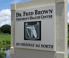Dr. Fred Brown - Sign faces with flat-cut decoration on existing monument structure